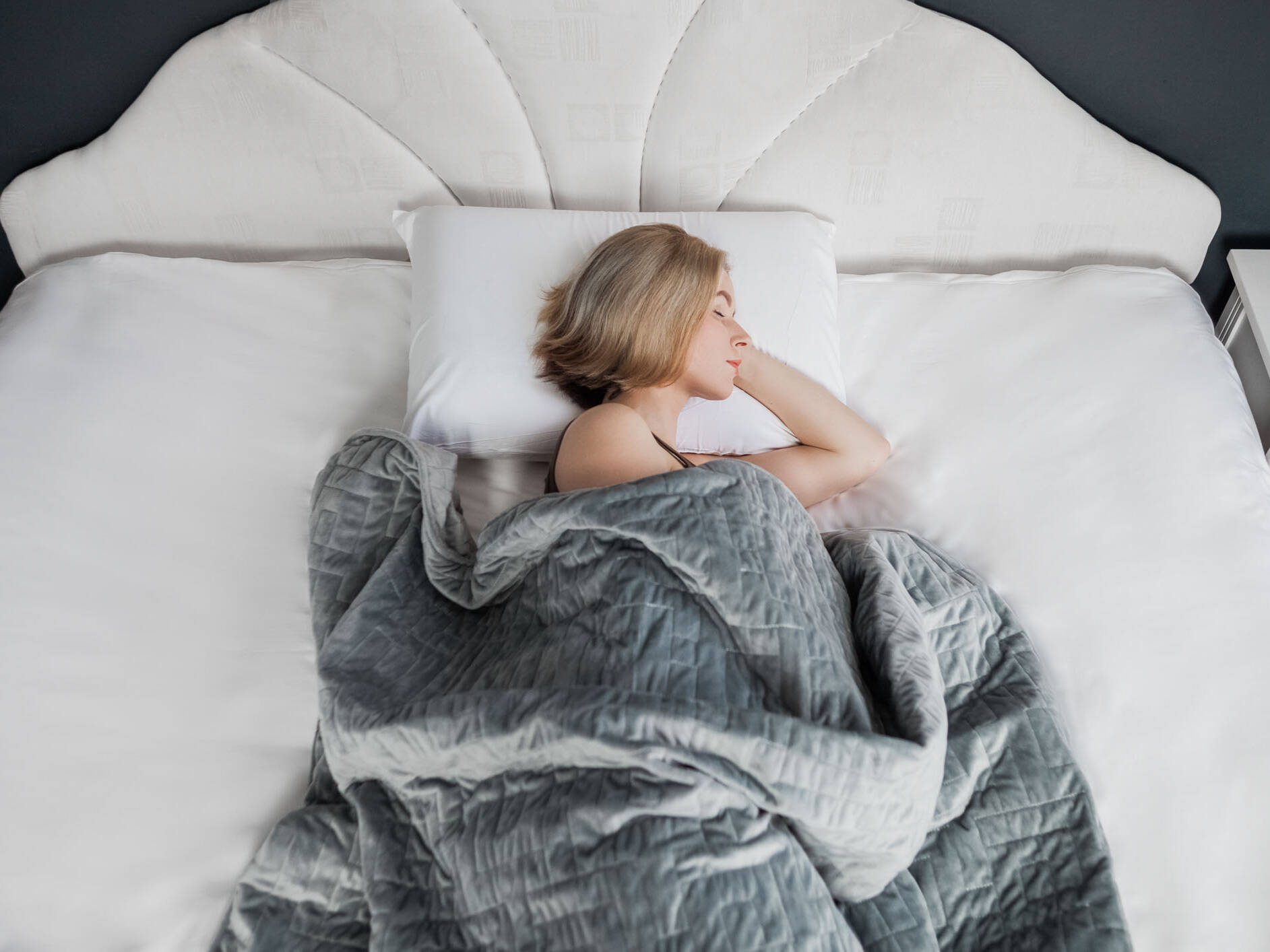 Γυναίκα σε lifestyle φωτογράφιση με γκρι κουβέρτα σε εσωτερικό χώρο